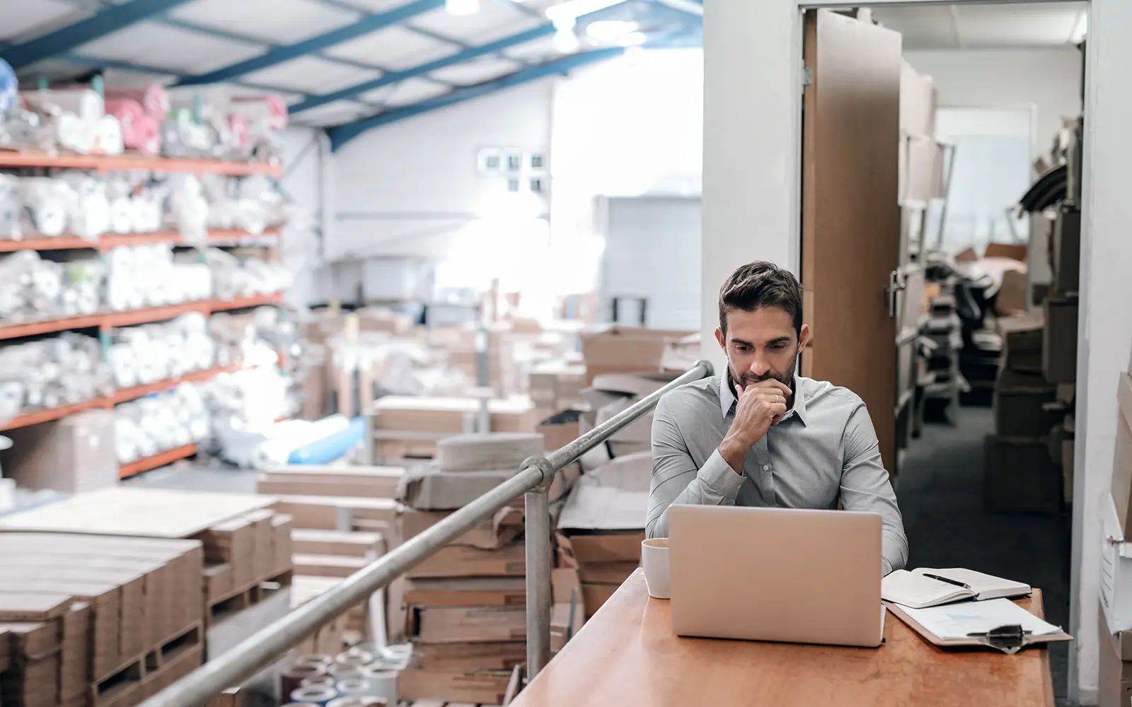 Ondernemer werkt in zijn magazijn met laptop – e-commerce die werkt in de praktijk