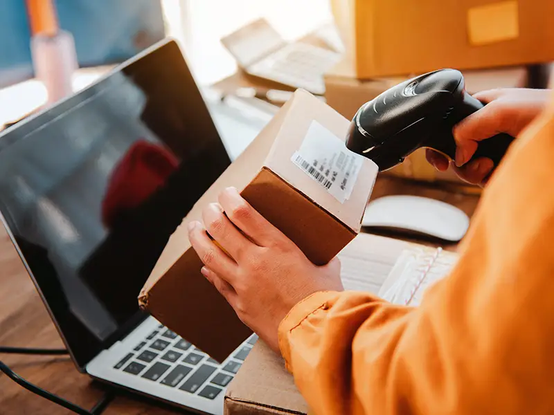 Medewerker scant pakket met barcode voor productinformatie en contentbeheer – retailZ helpt MKB met consistente productdata.